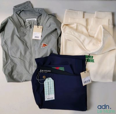 Trois pantalons pour homme et une veste sont posés sur une table