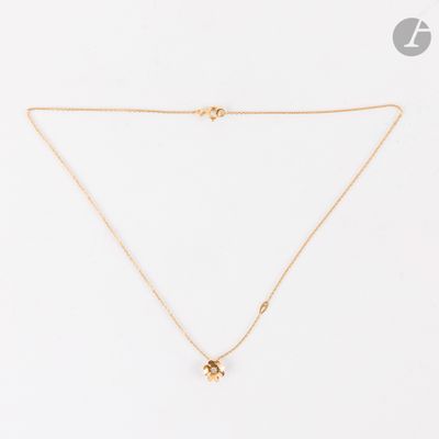 un collier en or avec un pendentif en diamant sur fond blanc