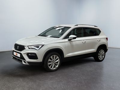 un SUV blanc garé dans une pièce au sol noir