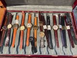 many different types of watches in a red case