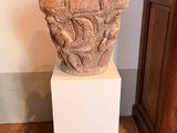 un vase en pierre posé sur un socle dans une pièce