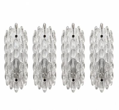 trois appliques en verre transparent accrochées à un mur blanc