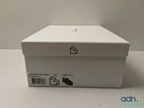 an empty white box sitting on top of a table next to a white wall