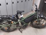 un vélo vert avec un sac attaché à l'arrière