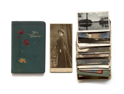 a stack of old photographs and a book sitting on a table