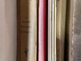 several old books are stacked on top of each other on a shelf