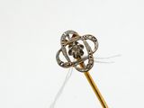 un bâton en or surmonté d'une fleur en diamant