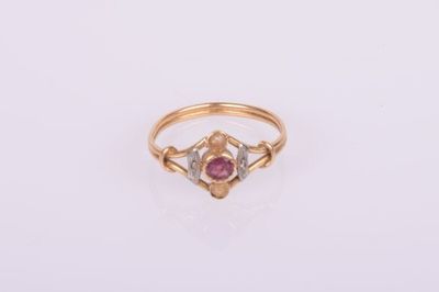 gros plan d'une bague en or avec une pierre rose