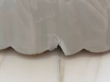 a close up of a white vase on a table