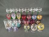 many different colored wine glasses sitting on a table