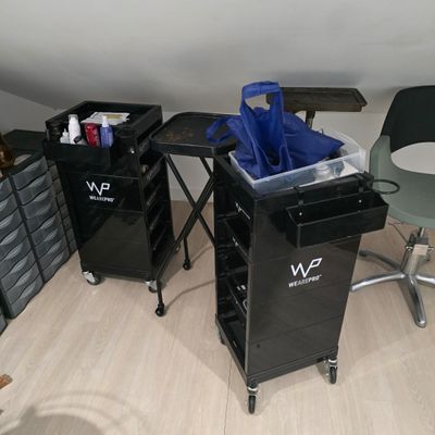 deux poubelles noires posées par terre à côté d'une table