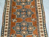 a brown and blue rug on a blue floor next to a white wall