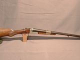 un vieux fusil avec une poignée en bois sur fond blanc