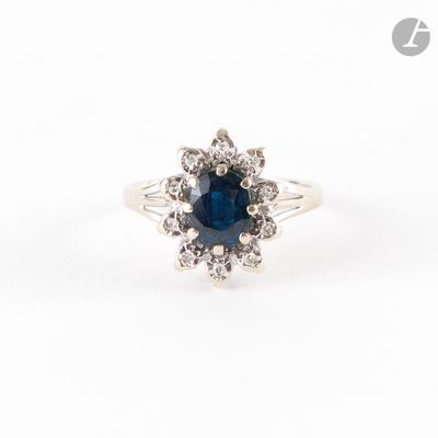 un gros plan d'une bague en saphir et diamants sur fond blanc