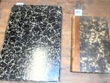 deux vieux livres posés sur une table en bois, avec un crayon