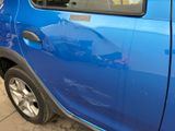 a small blue car parked on the side of the street