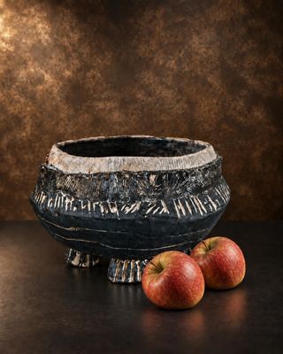 two apples that are sitting on a table next to a bowl
