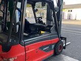 a red forklift parked in front of a gas station