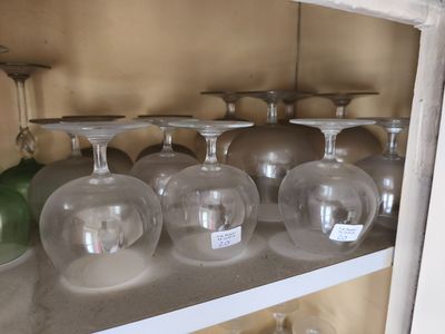 de nombreux verres à vin vides sur une étagère dans la cuisine