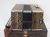 a black and gold accordion sitting on top of a wooden box