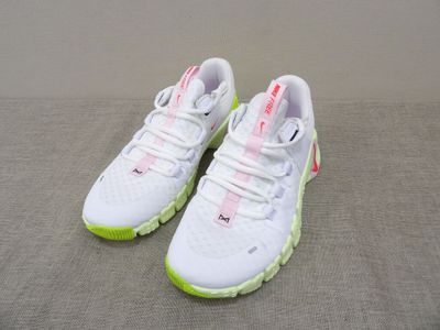a pair of white sneakers with neon green soles on a gray surface
