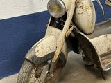 an old motorcycle that is parked in a garage