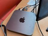 an apple computer sitting on a desk with a red chair