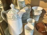 de nombreuses tasses et soucoupes posées sur une étagère en verre