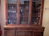 un grand meuble en bois avec des portes en verre dans une pièce