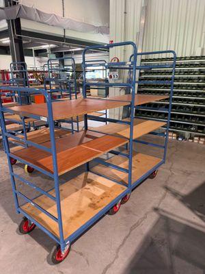de nombreuses étagères, sur lesquelles sont posées des tablettes en bois, dans un entrepôt