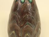 a brown vase with a green decoration on it
