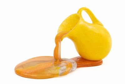 un liquide orange qui s'écoule d'une cruche jaune