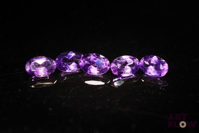 a group of purple gems sitting on top of a black surface