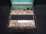 an old accordion sitting in a case on a black surface