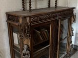 une armoire en bois avec une porte vitrée et une horloge posée dessus