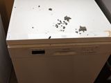 a small white refrigerator in the corner of a room