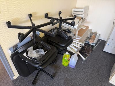 a picture of a room with a desk, chair, printer, and other items