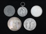 quatre pièces d'argent et une pièce d'argent posées sur une surface noire