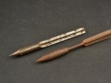 two pens and a pencil sitting on a table
