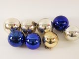 a bunch of shiny blue and silver ornaments on a white surface