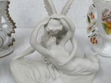 a statue of a woman sitting on a pillow next to vases