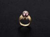 a pink pearl and diamond ring on a black surface