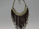 beaded necklace with cowrie and shell beads on a wooden stand