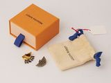an orange box with a blue handle and some small pieces of jewelry in it