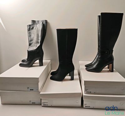 trois paires de bottes noires sont empilées les unes sur les autres