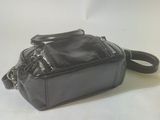 black leather handbag on a white background with a black strap