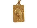 a gold plated pendant with a woman ' s face on it