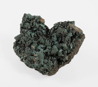 a close up of a piece of green rock on a white surface
