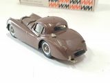 a brown toy car sitting on a table next to a box