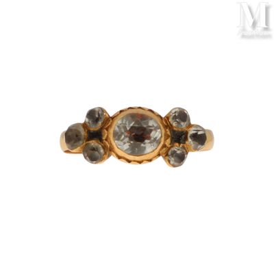 a close up of a gold ring with a white diamond